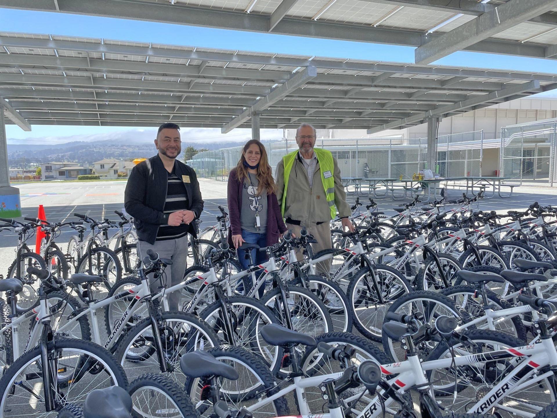 Sunshine Gardens Elementary School Principal Leticia Gonzalez poses with South San Francisco Council Members Eddie Flores and Mark Addiego during the city of South San Francisco's 2023 bike giveaway event.