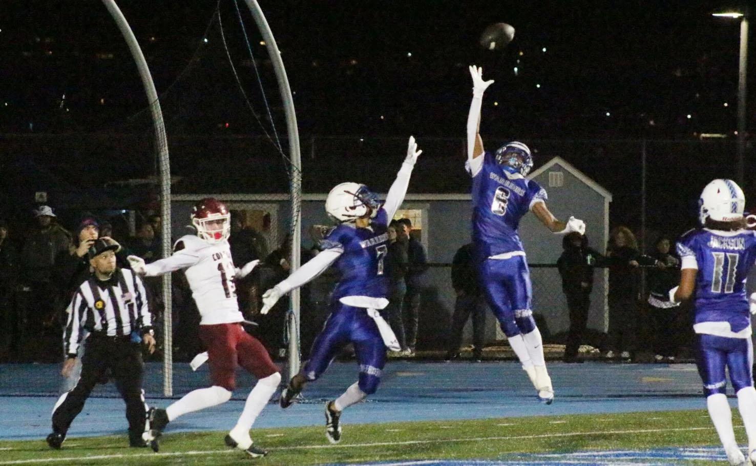 South City senior Justice Goodman, right, defends with Darren Miller, middle, on a potential interception just out of their reach in the CIF Northern California Division 6-A regional championship game Saturday night at Clifford Field. (Terry Bernal/Daily Journal)